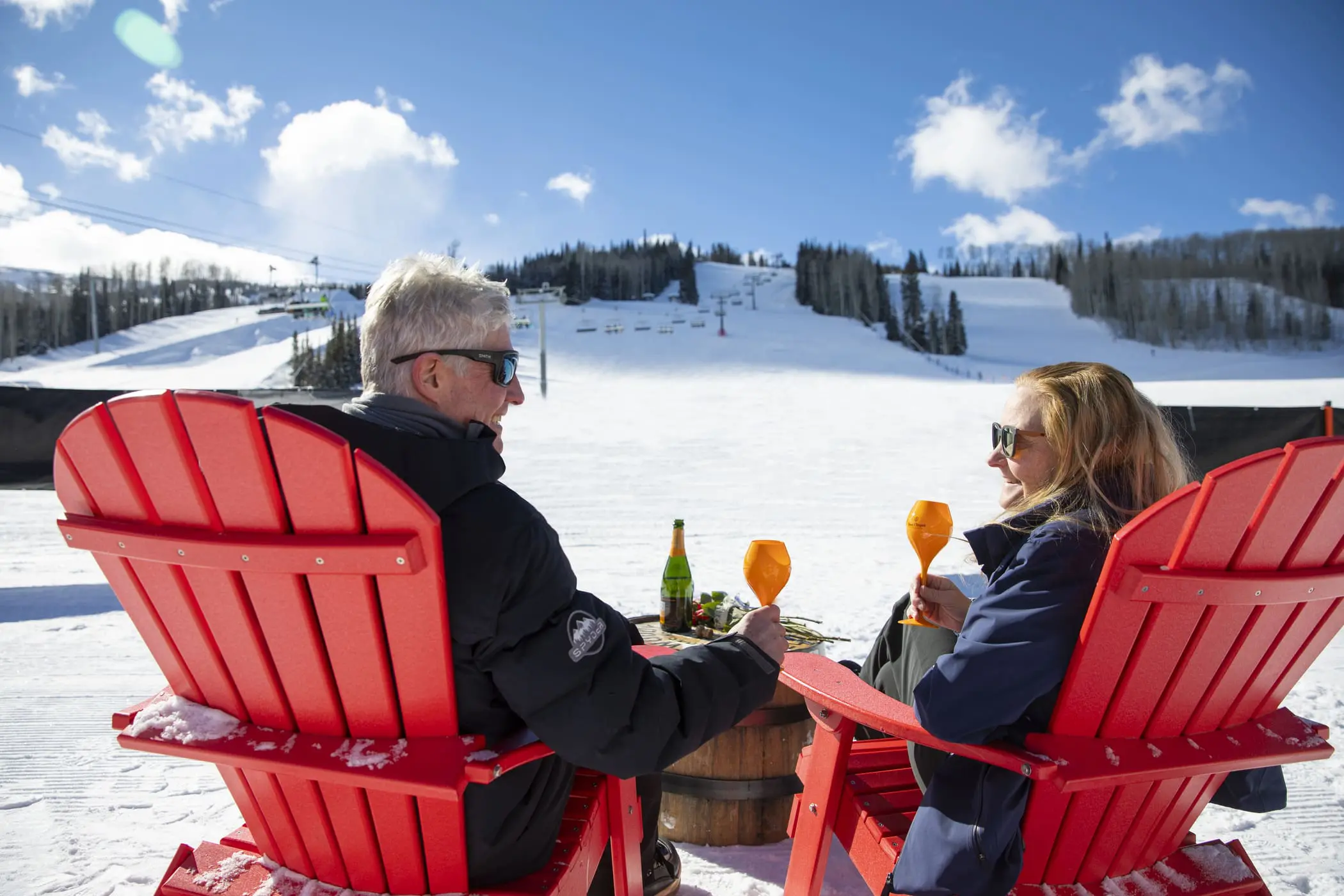 couple cheers and enjoys dining at on-mountain restaurant the cabin aspen snowmass colorado apres ski