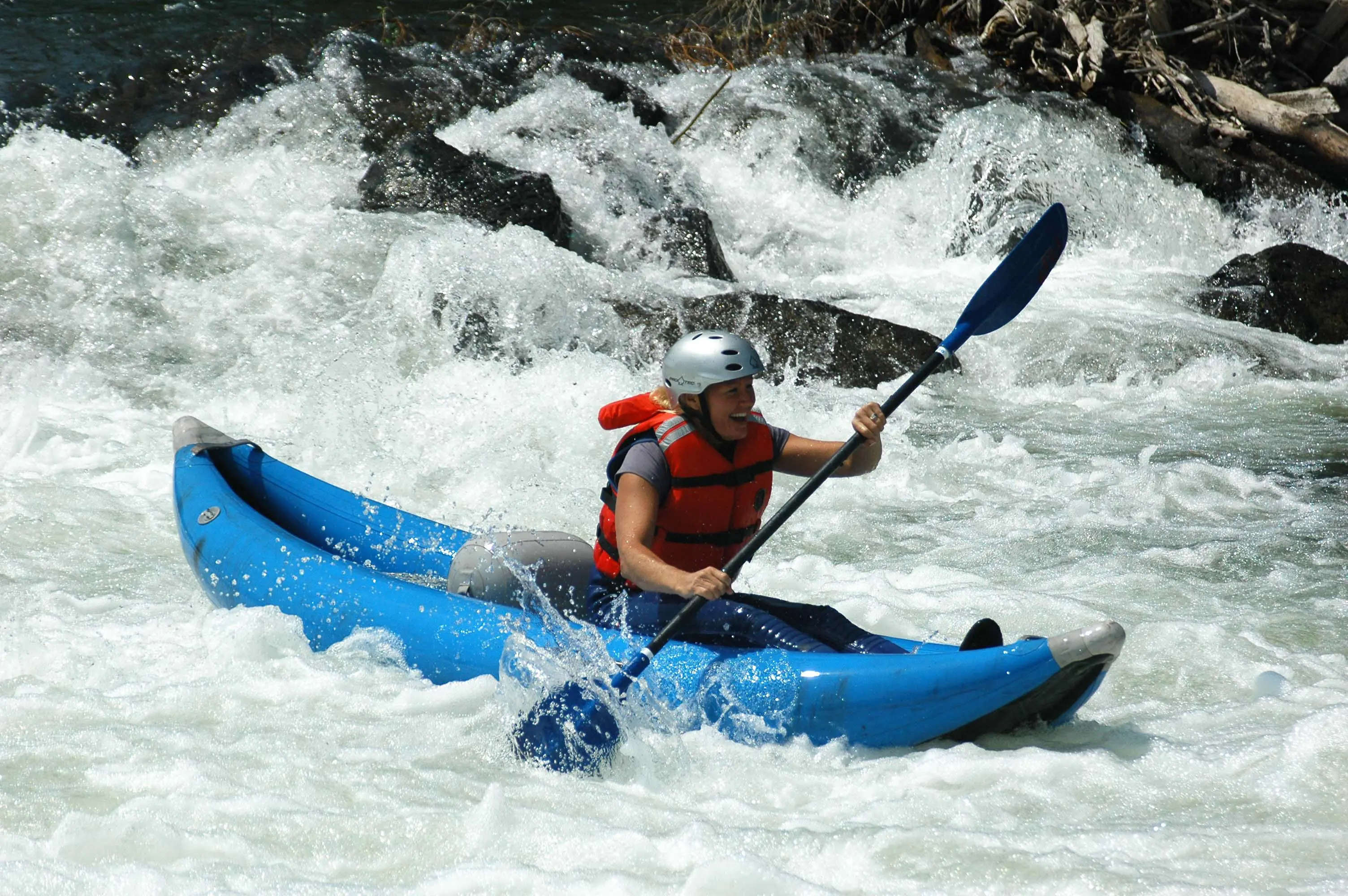 woman kayaking in inflatable ducky in Roaring Fork River