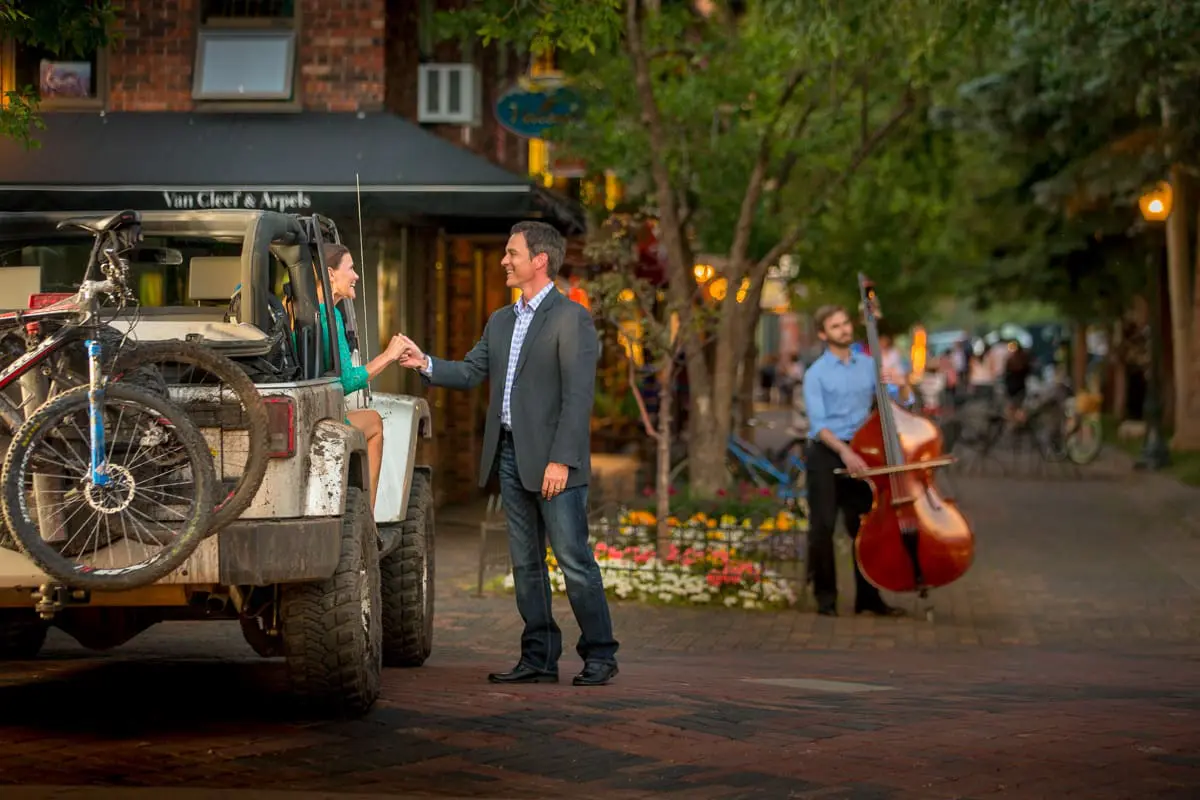 Couple shaking hands next to a jeep in Snowmass village