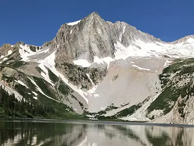 Mountain infront of lake with snow on it