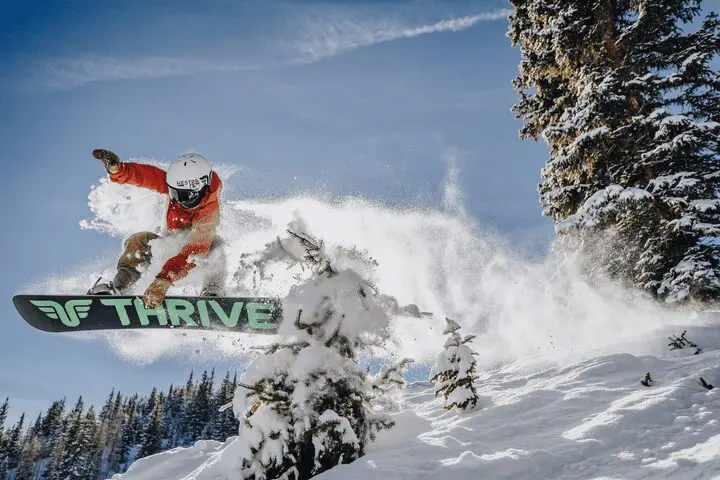 snowboarder getting air and grab while shredding in Snowmass