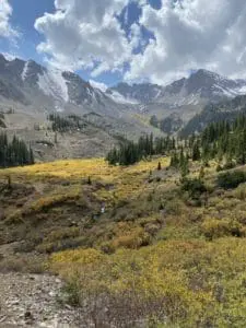 Cathedral Lake hike in Aspen, Colorado with snowy peaks and fall foliage.