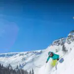 People skiing down steep hill