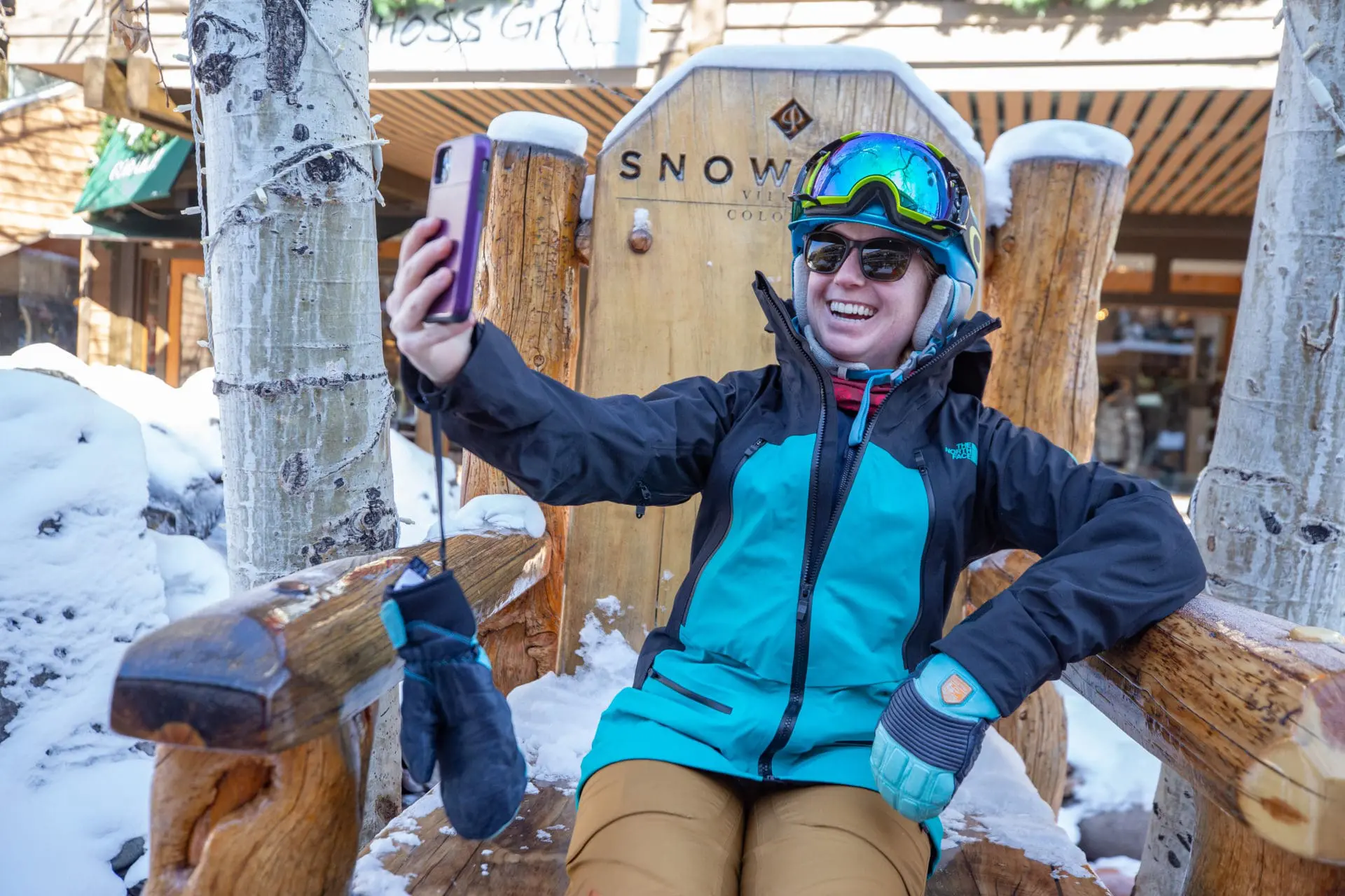 Person wearing ski gear taking selfie with mobile phone