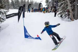 Young snowboarder competing in banked slalom event at Snowmass Ski Area.