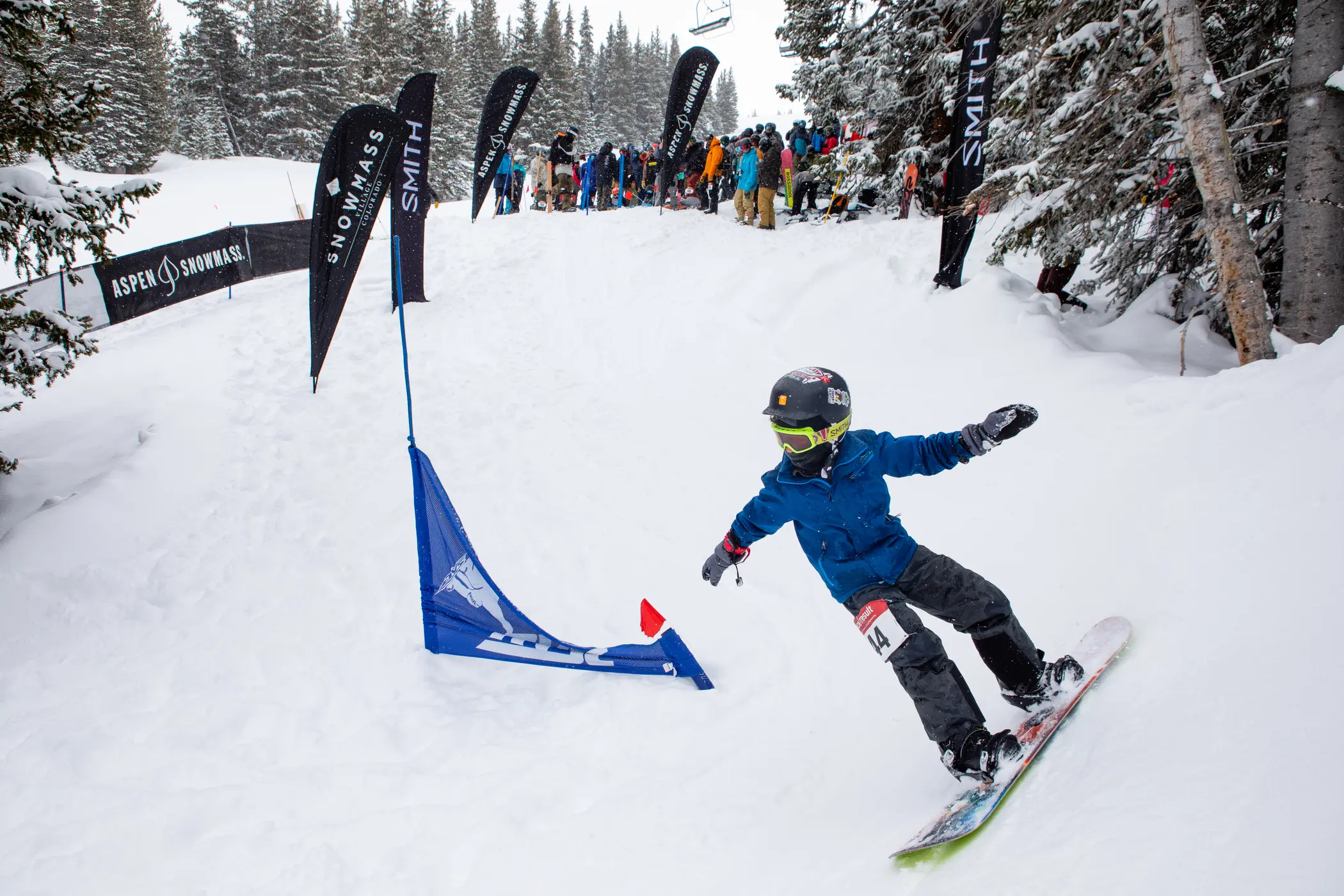 Young snowboarder competing in banked slalom event at Snowmass Ski Area.