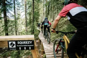 Three mountain bikers from Snowmass 50 on Squeezy, a Snowmass mountain bike trail.