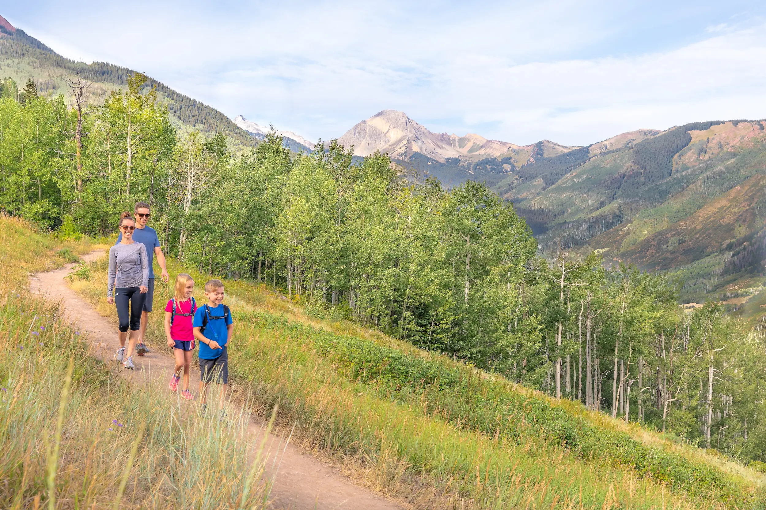 family with two little kids going on a hike in the mountains of Colorado during their summer vacation