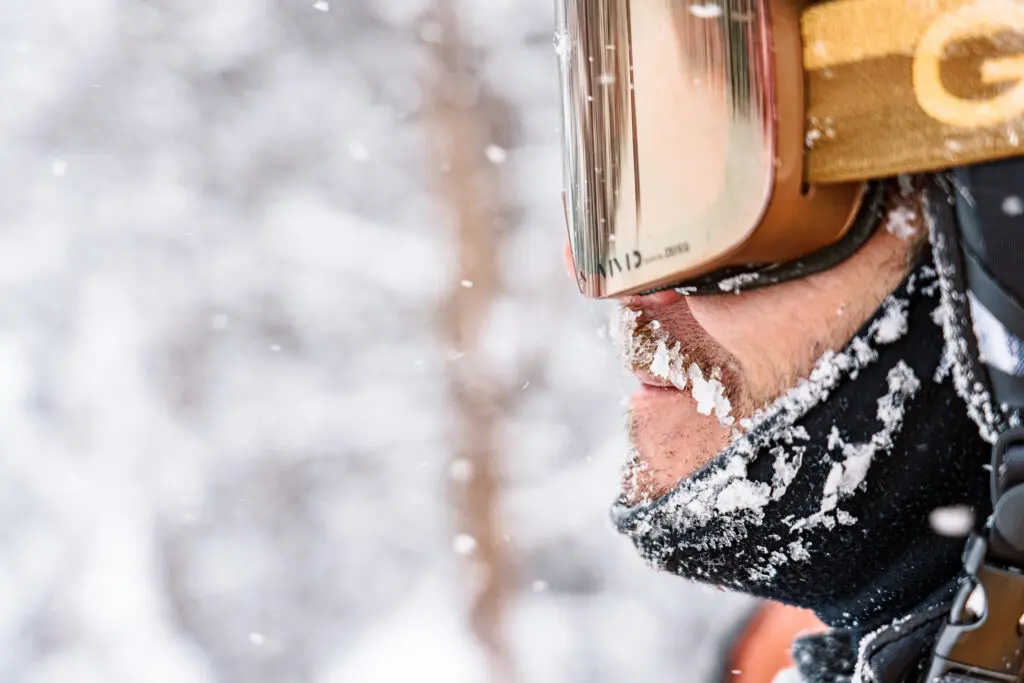 A skier with goggles and a neck gaiter in the snow in Snowmass.