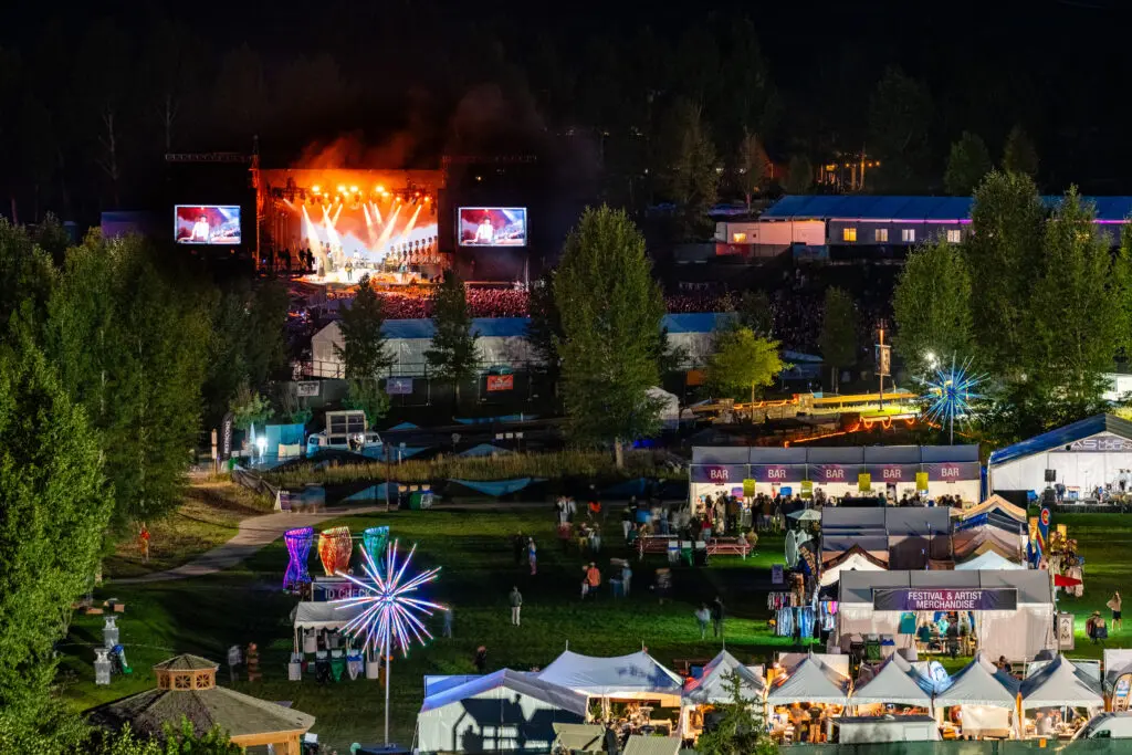 JAS Festival of music in Snowmass at night, with the vendor village in the foreground and the main stage lit up in the background.