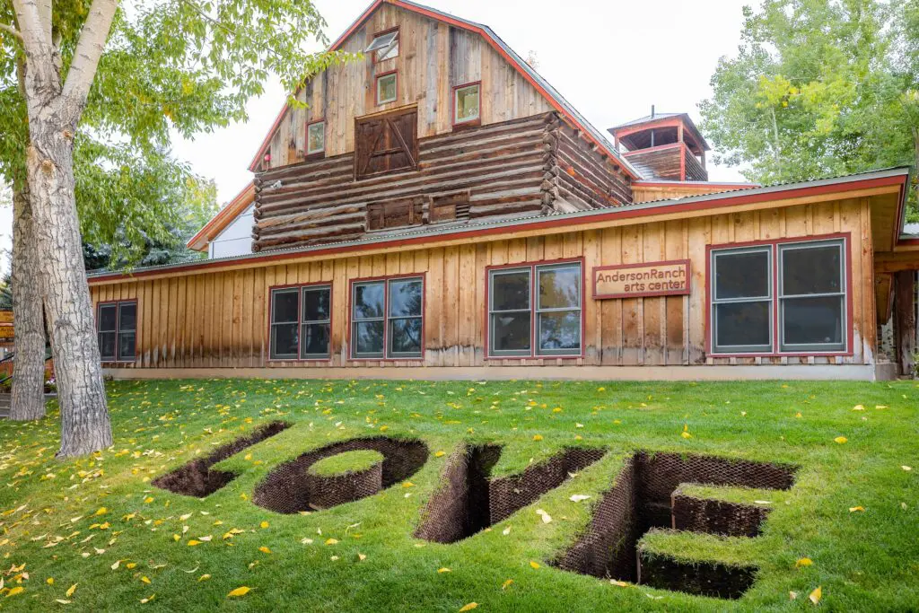 art of the word love dug into the green summer grass outside of the Anderson Ranch arts attraction in Aspen Colorado