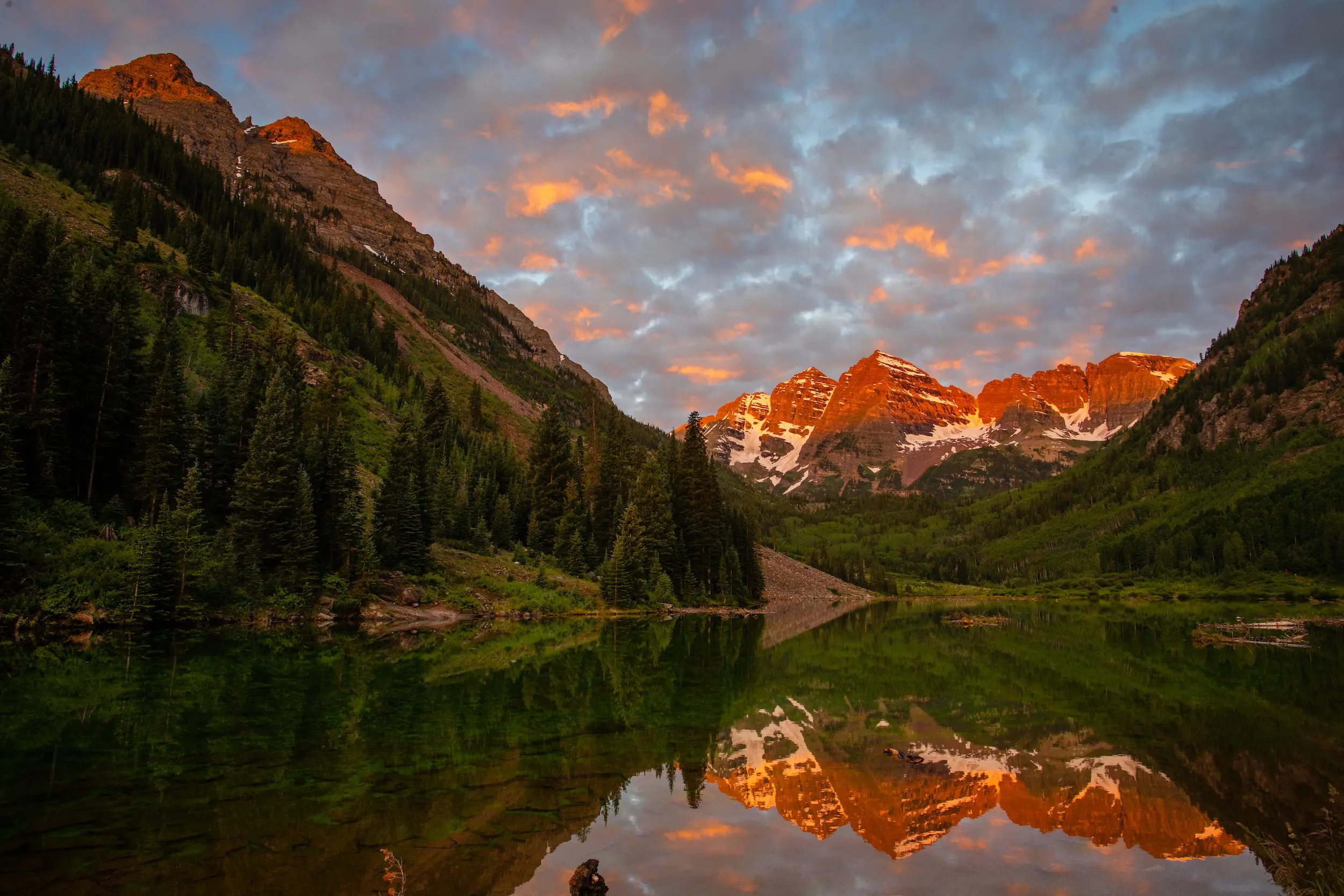 alpenglow on the mountains at the Maroon Bells attraction during summer in Aspen Colorado