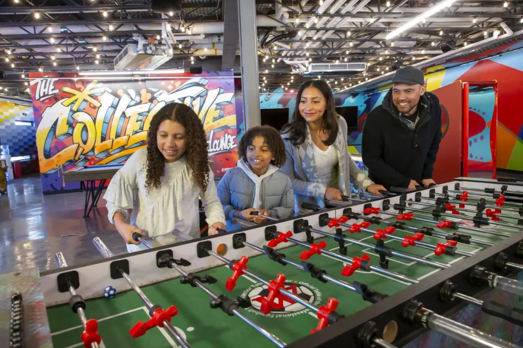family of four plays foosball as an indoor activity in snowmass