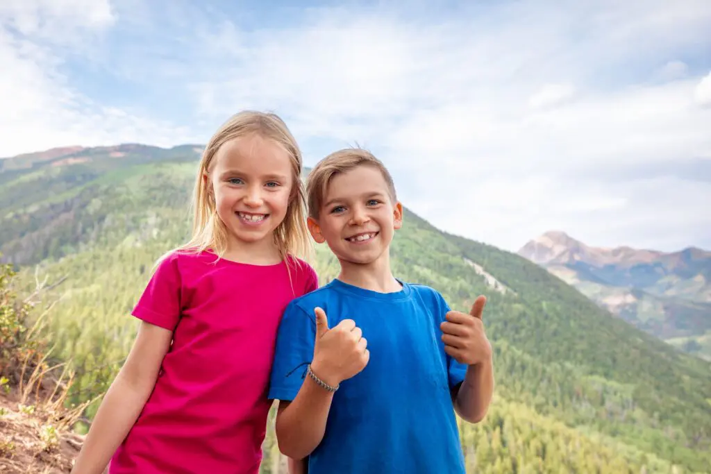 two young kids on a hiking attraction in the mountains near Aspen Colorado in the summer