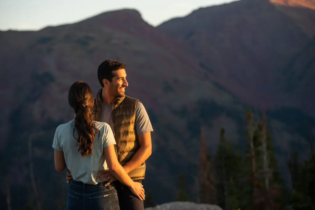 man and a woman standing at the top of a hiking trail at sunset in summer in Aspen Colorado