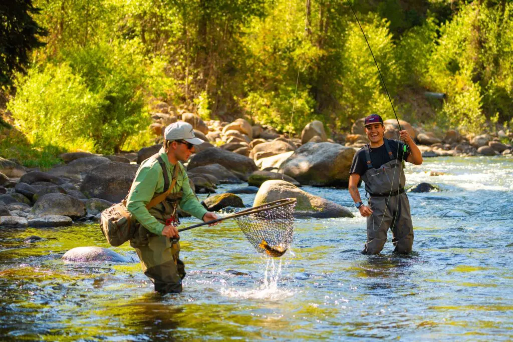 two men fishing in a river outside of Aspen during the summer
