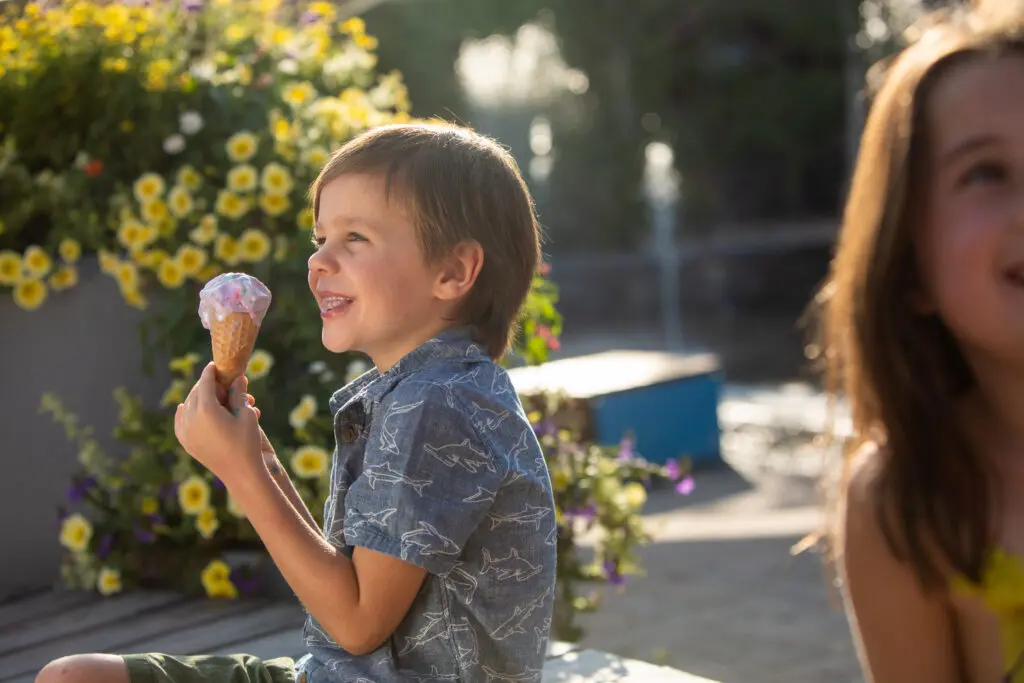 a toddler in snowmass eats an ice cream cone in snowmass base village