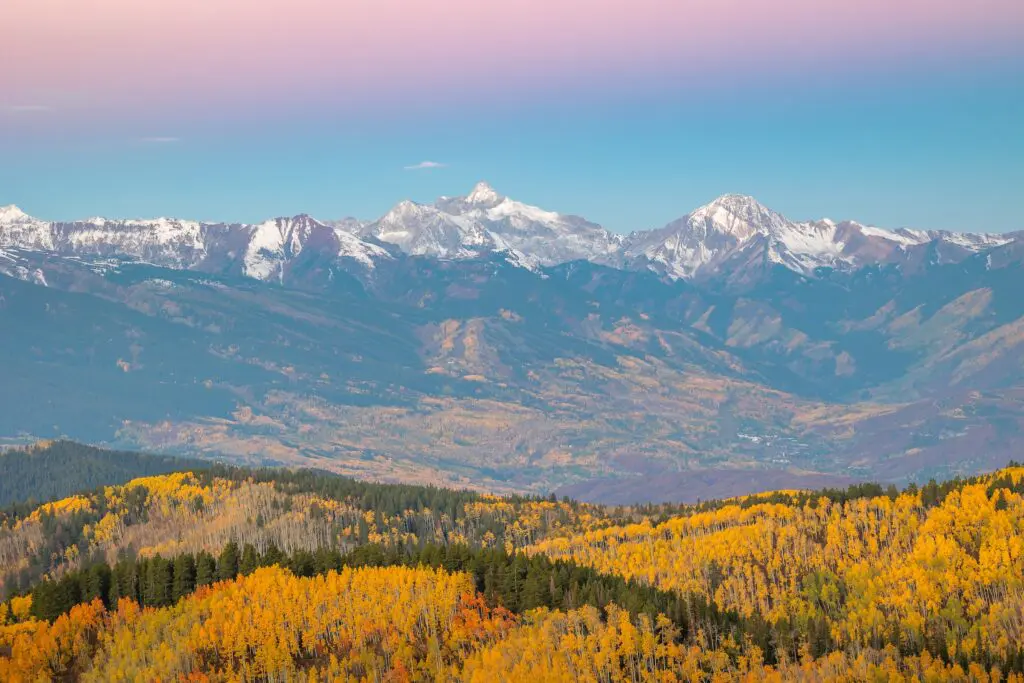 snow topped mountains near Aspen Colorado with fall foliage in the foreground as the leaves change color