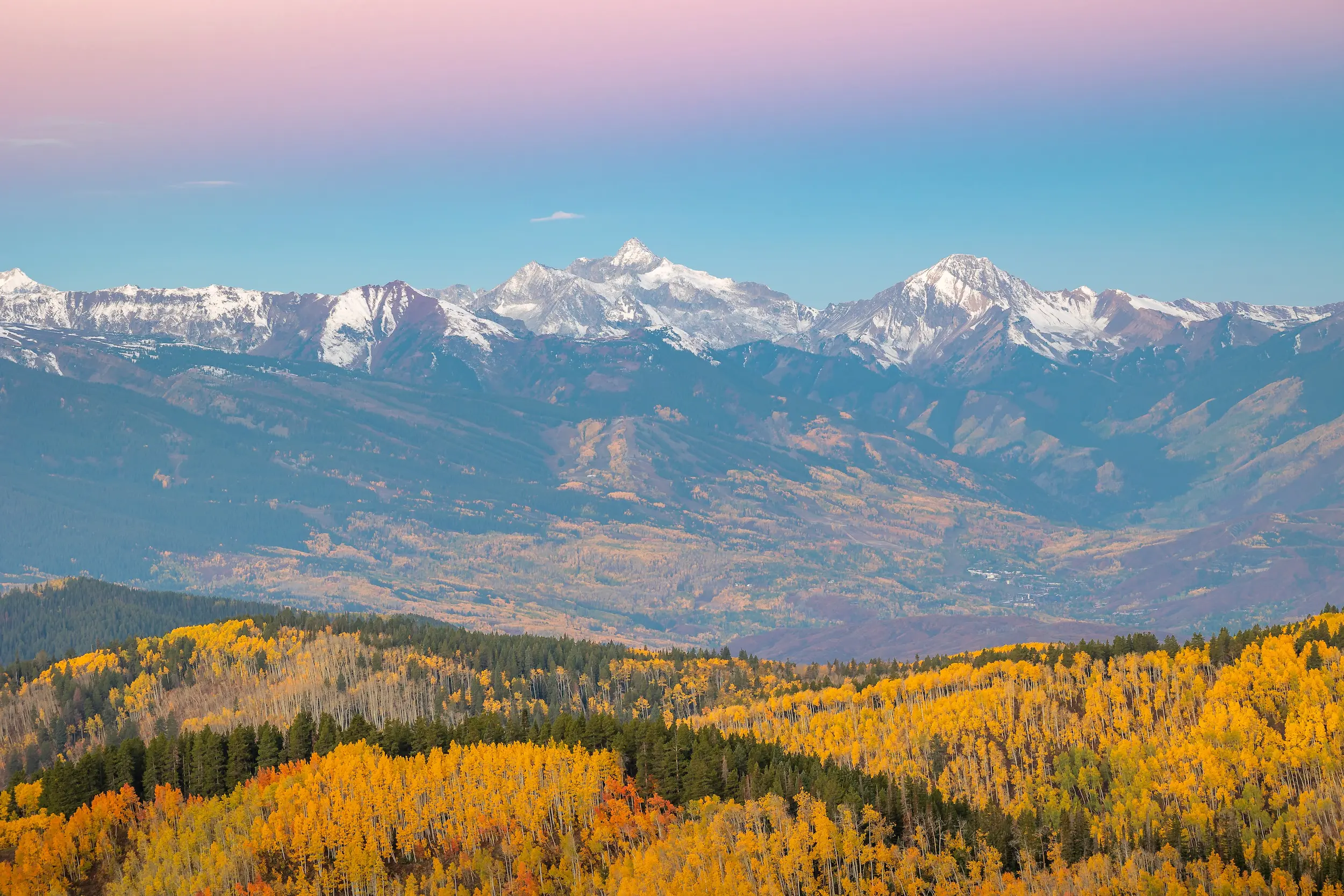 snow topped mountains near Aspen Colorado with fall foliage in the foreground as the leaves change color