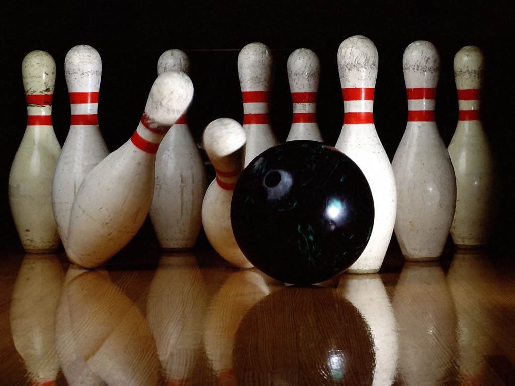 bowling ball striking pins on lane