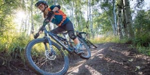 Woman Mountain biking in aspen grove at snowmass ski resort