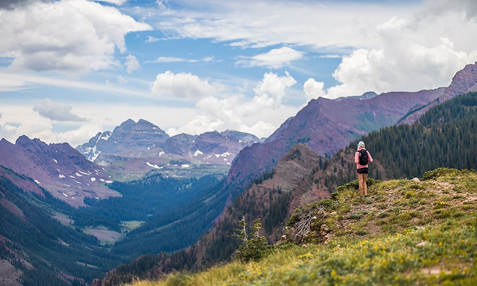 hiker enjoying secretive view of the Maroon Bells