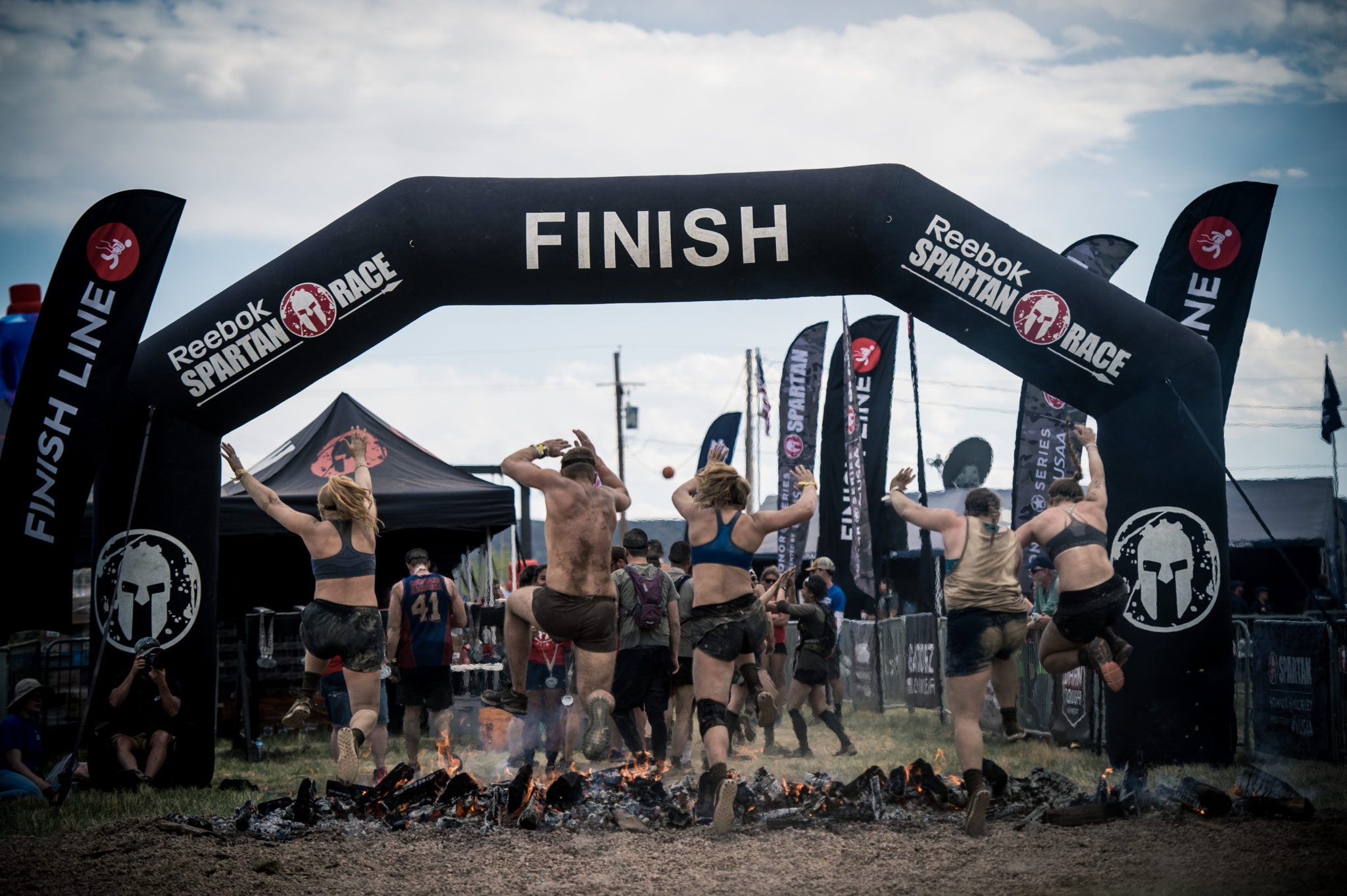five people crossing the finish line at a Spartan race