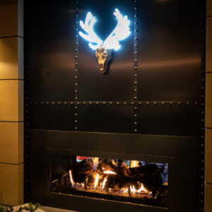 Neon elk horns above fireplace