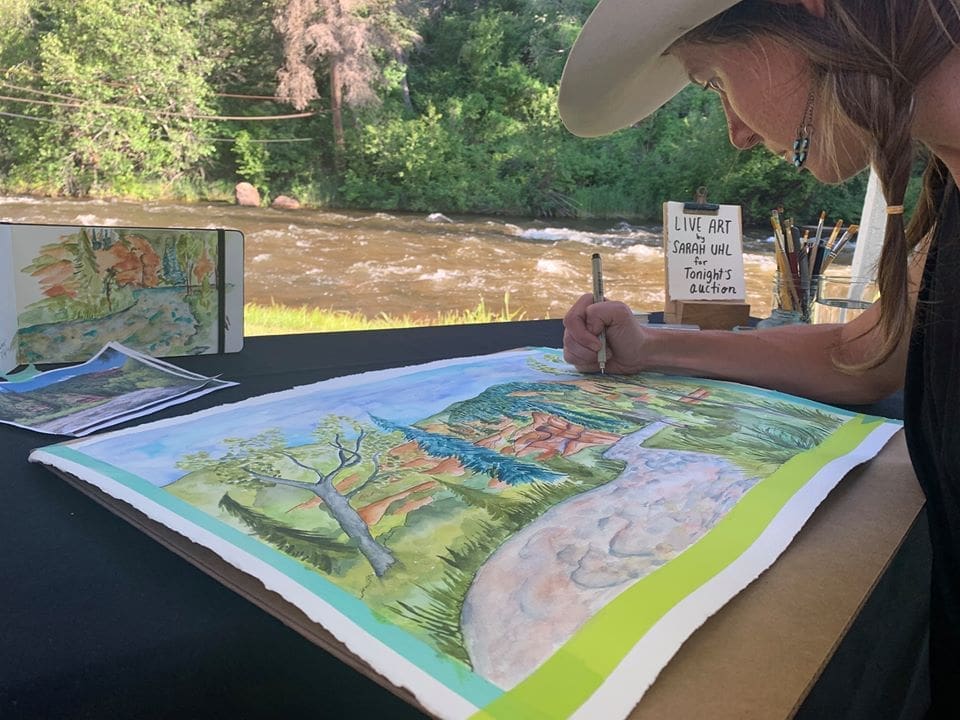 Person sketching a river she is next to