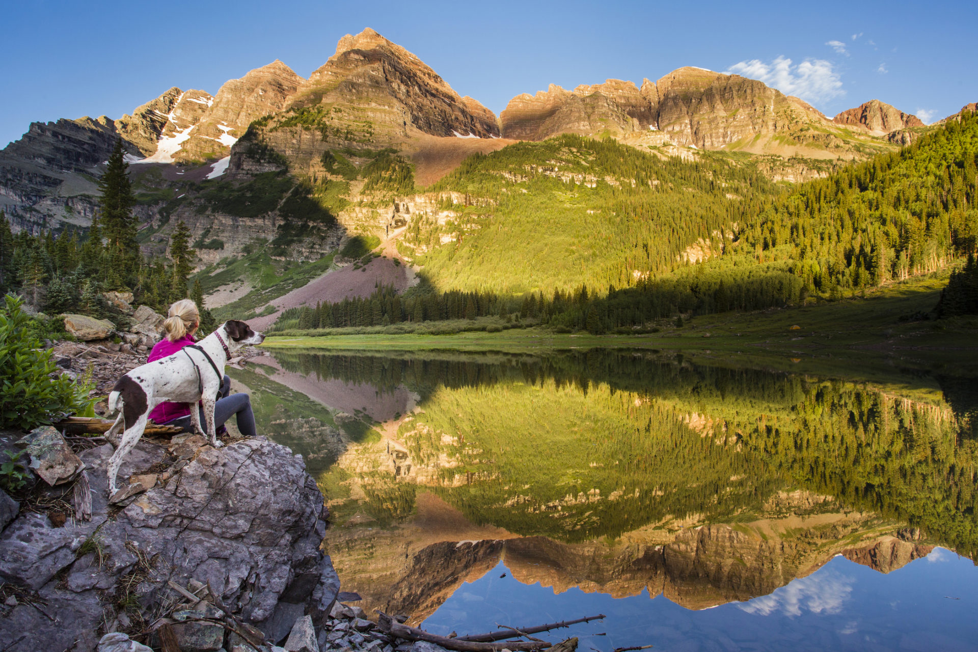 A dog and a woman sitting at a lake