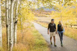 A couple walking a trail outside during fall