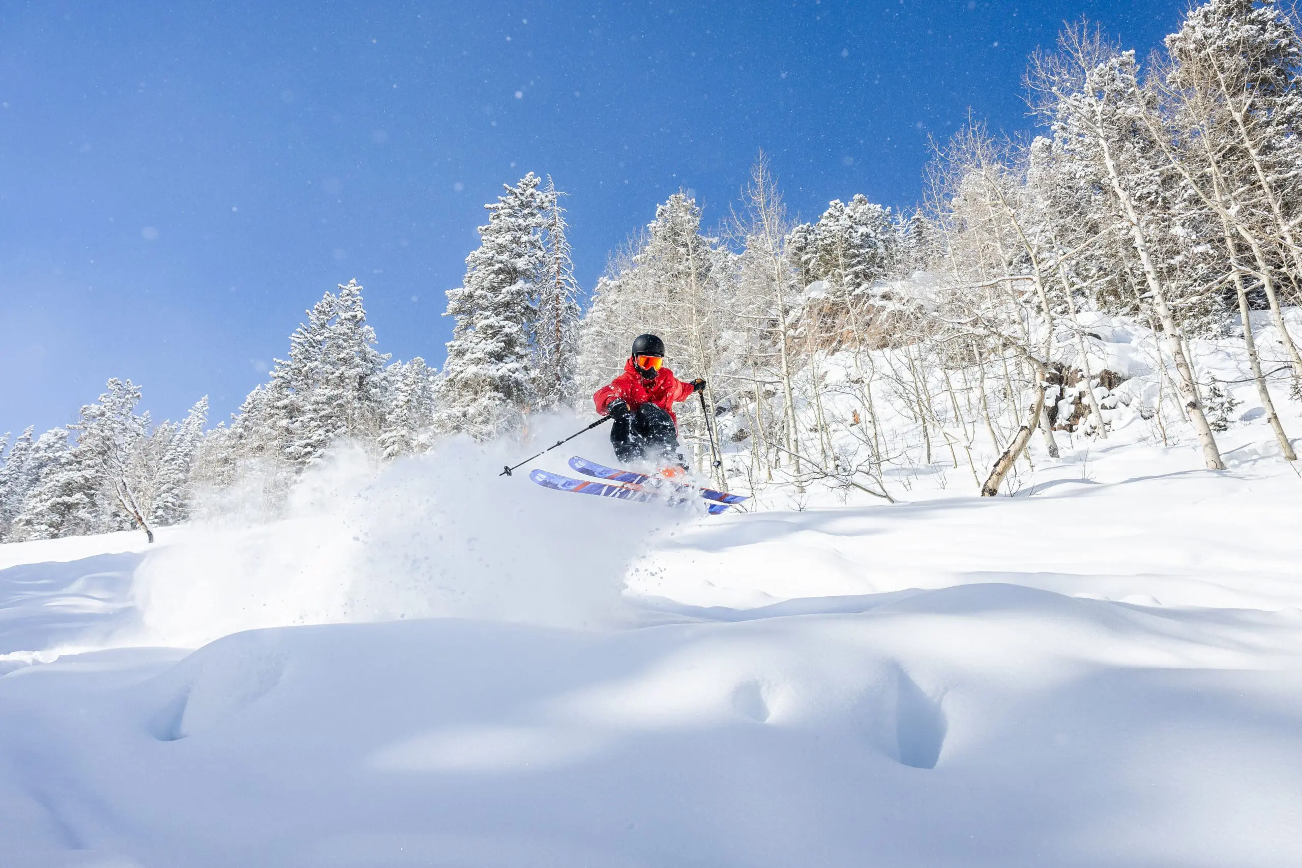 adult skier making jumps in fluffy powdery snow