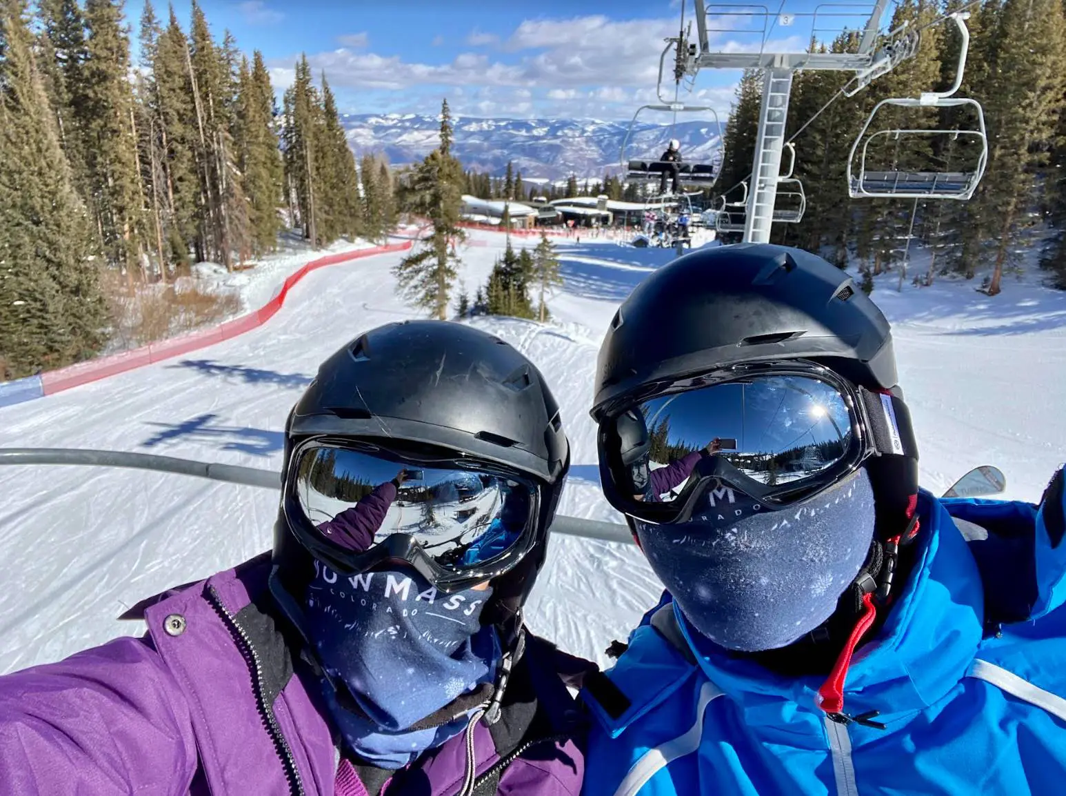 two people wearing goggles and ski masks while they learn how to ski for the first time