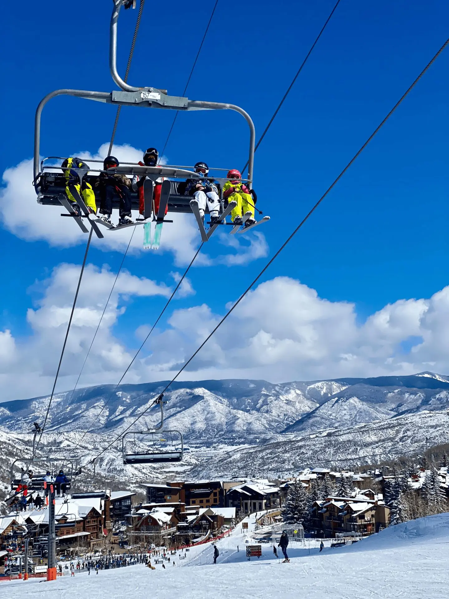 family of beginner skiers in a chairlift at Snowmass where they are learning how to ski